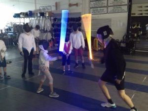 Photo of using light sabers at camp